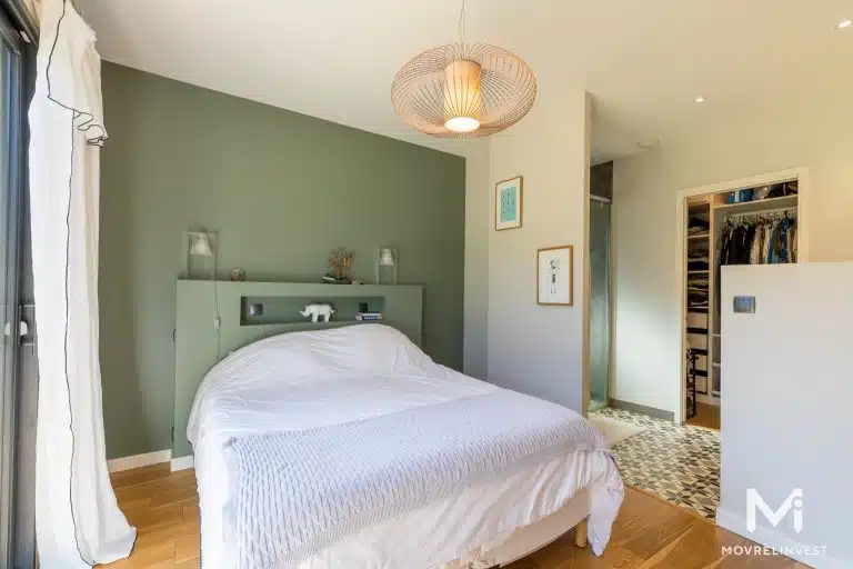 Chambre moderne avec mur vert et placard ouvert.