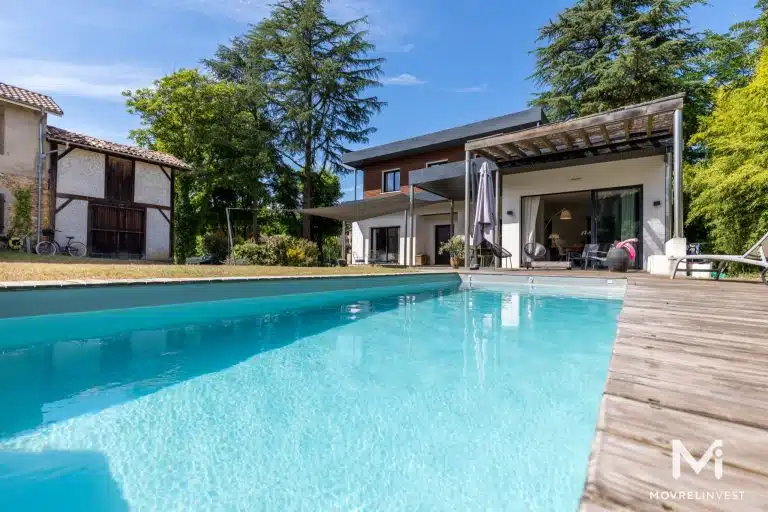 Maison moderne avec piscine et jardin.