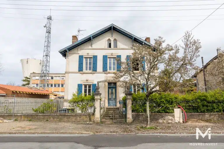 Maison traditionnelle française avec volets bleus.