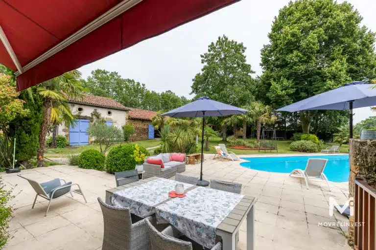 Terrasse avec piscine et maison traditionnelle française.