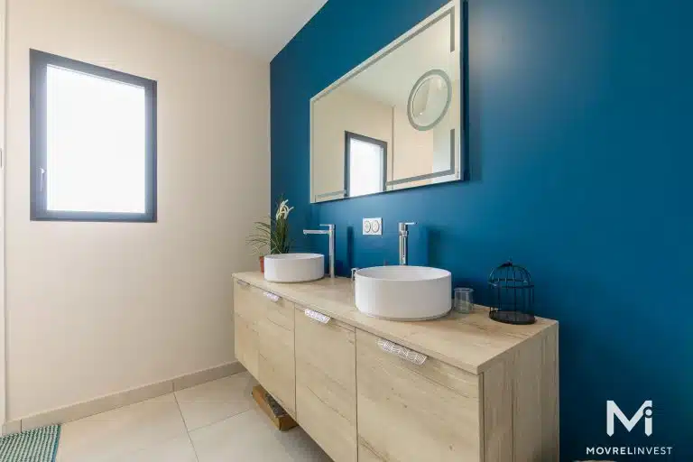 Salle de bain moderne bleue avec double vasque.