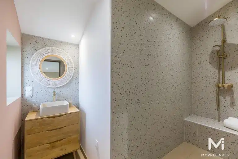 Salle de bain moderne avec douche et lavabo en bois.
