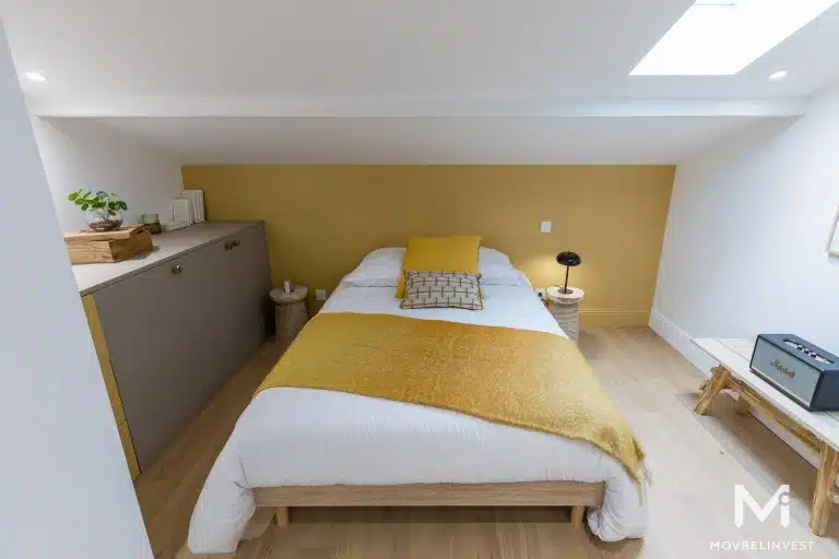 Chambre moderne aux tons jaunes et bois clair.