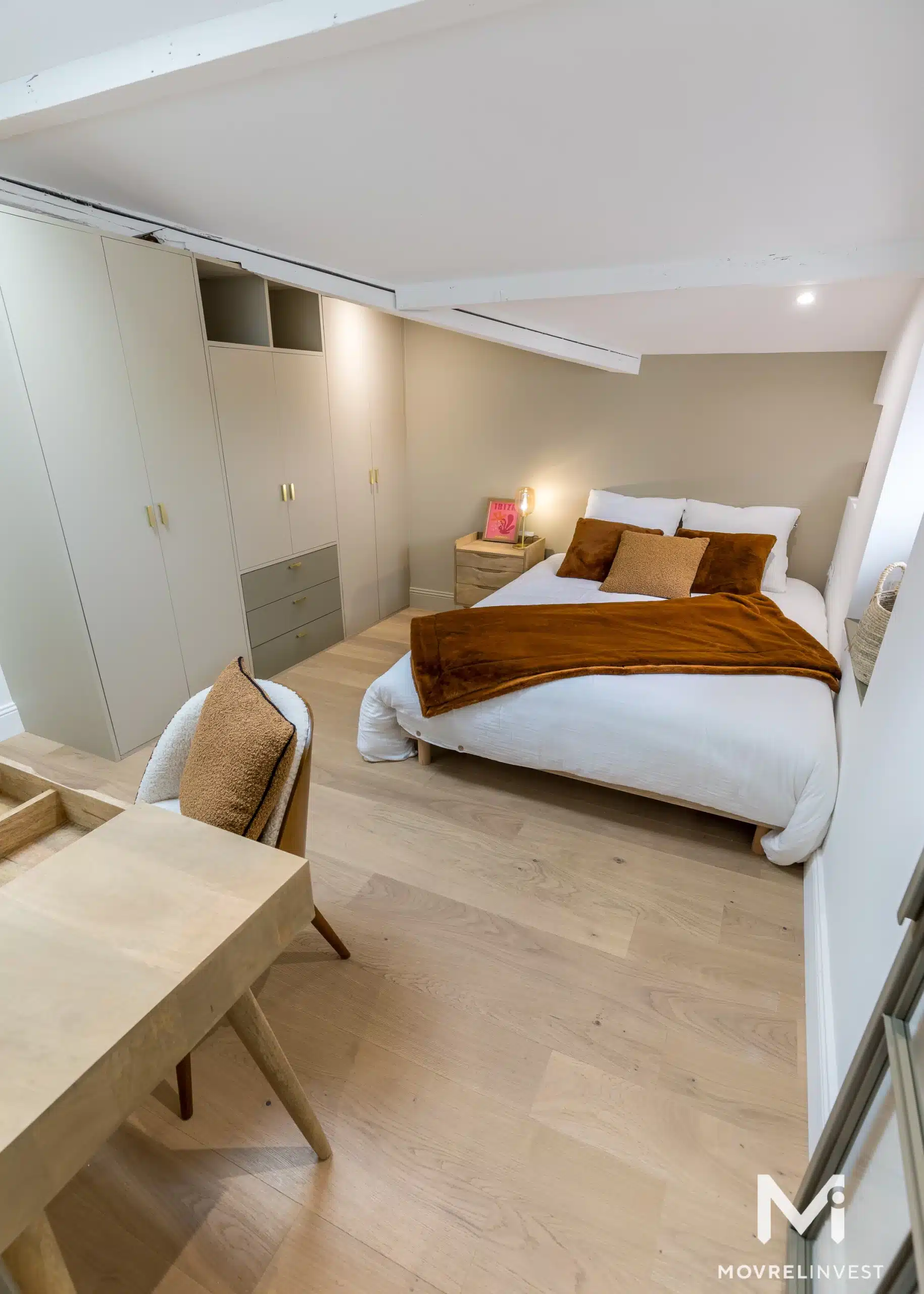 Chambre moderne et épurée avec lit double et rangements.