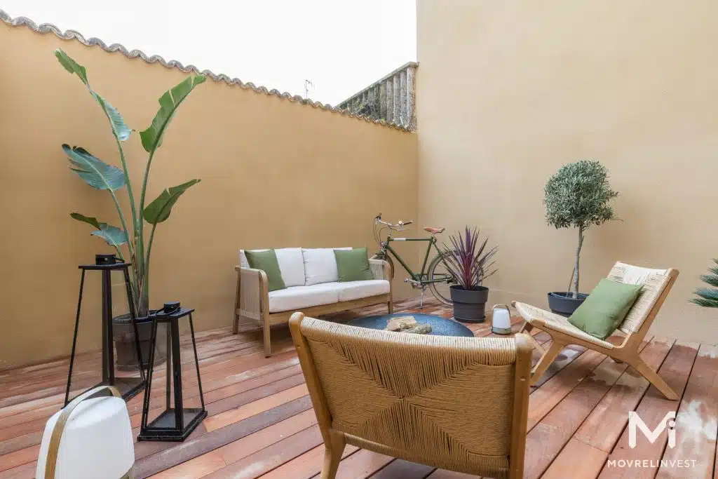 Terrasse urbaine cosy avec plantes et mobilier moderne.