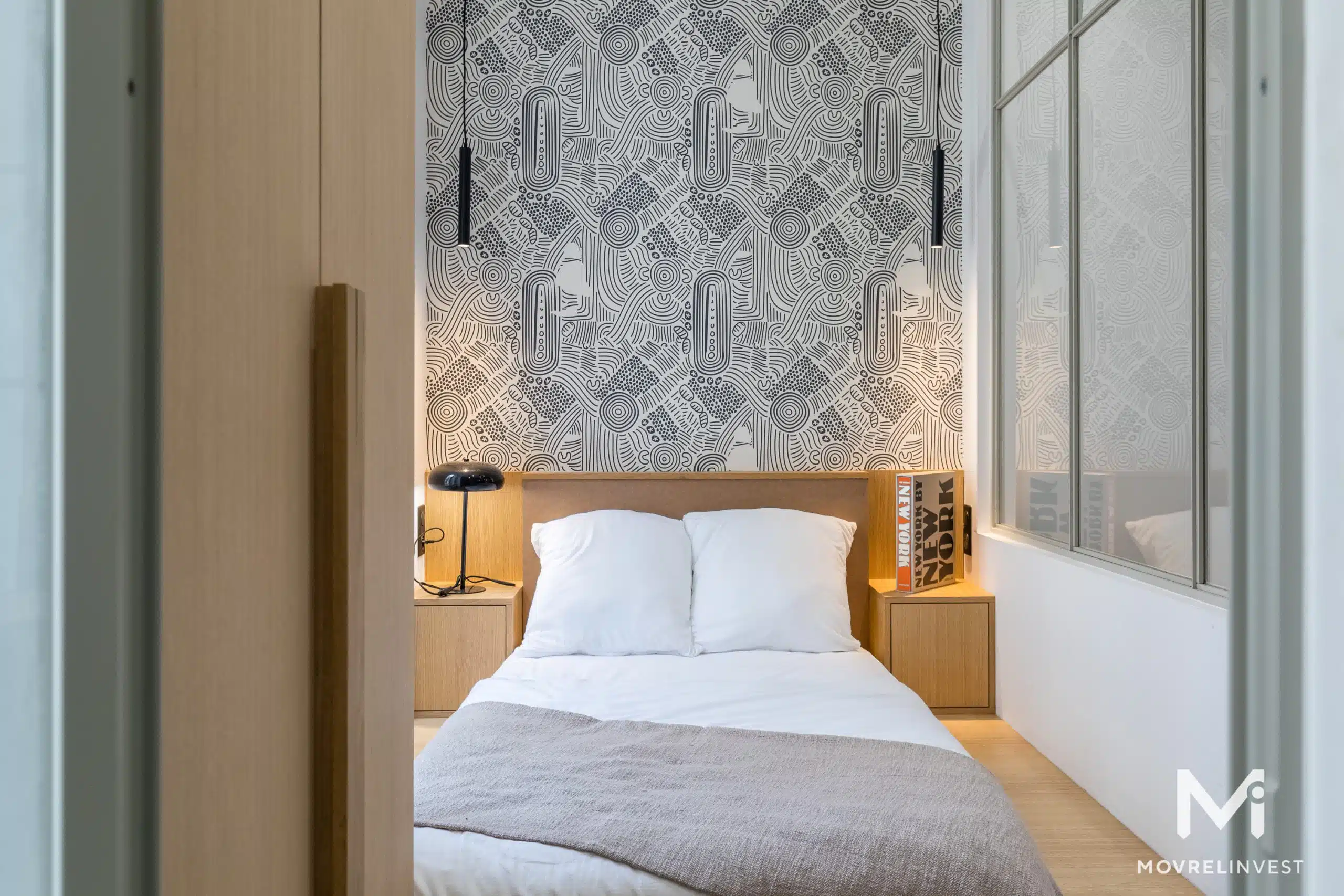 Chambre moderne avec papier peint géométrique et lit douillet.