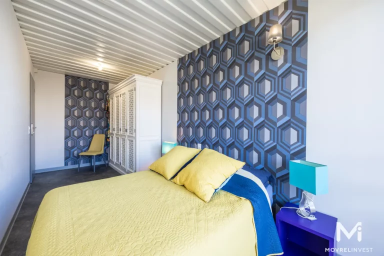Chambre moderne aux motifs géométriques et couleurs vives.