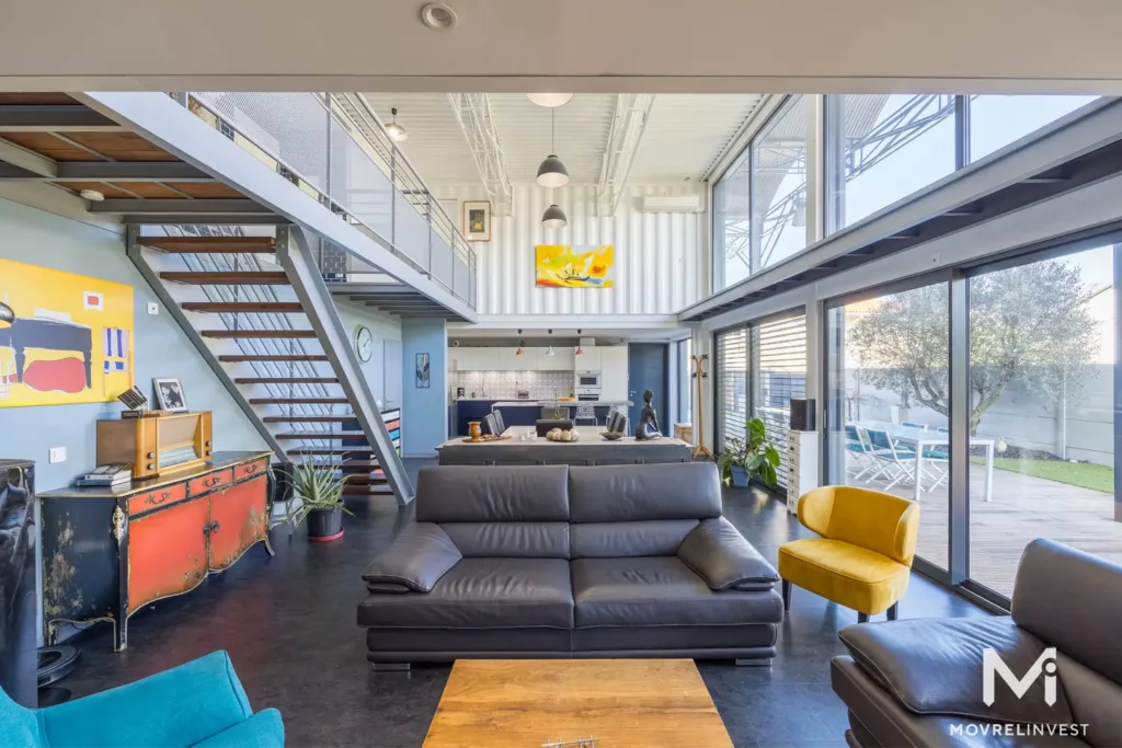 Intérieur moderne avec escalier et salon lumineux.