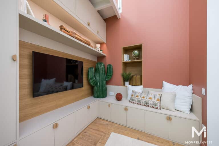 Salon moderne avec décoration cactus et coussins.