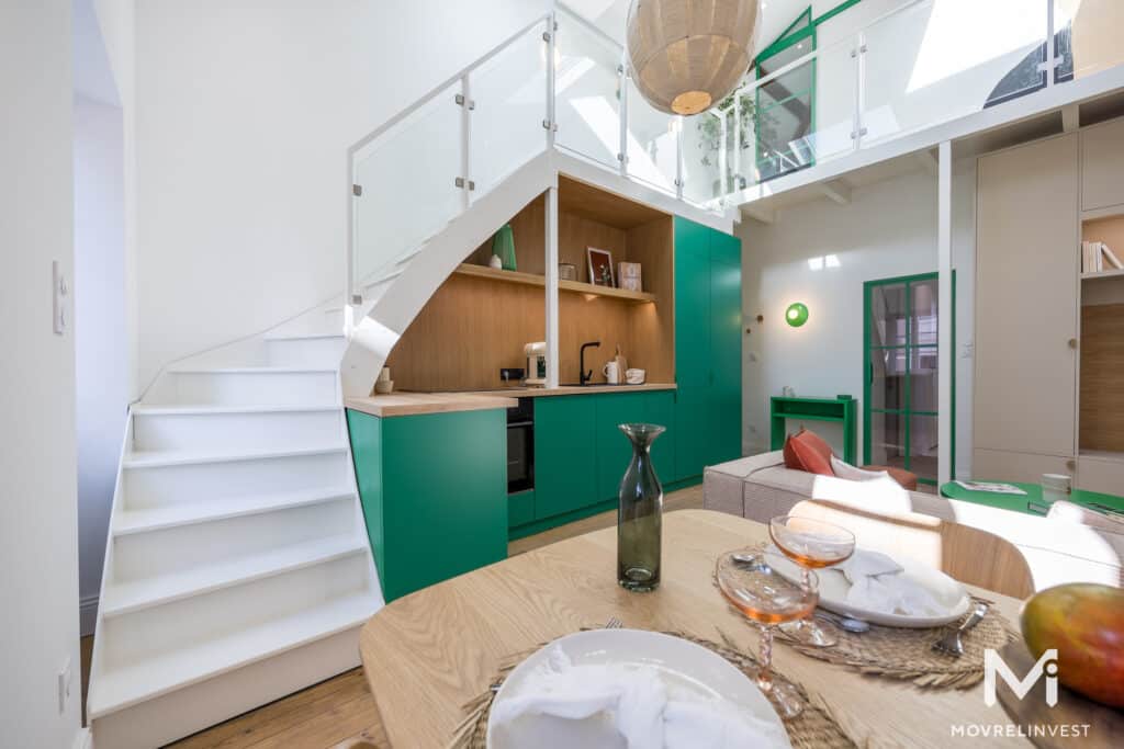 Intérieur moderne avec mezzanine et cuisine verte.