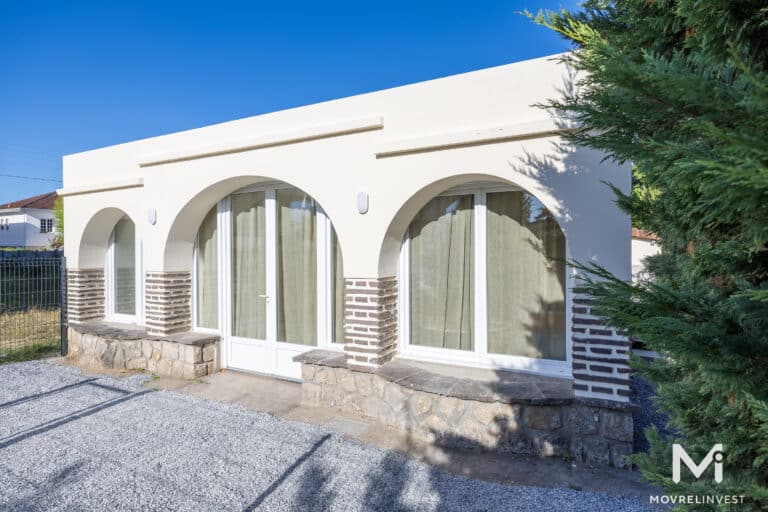 Façade moderne de maison avec arcs et jardin