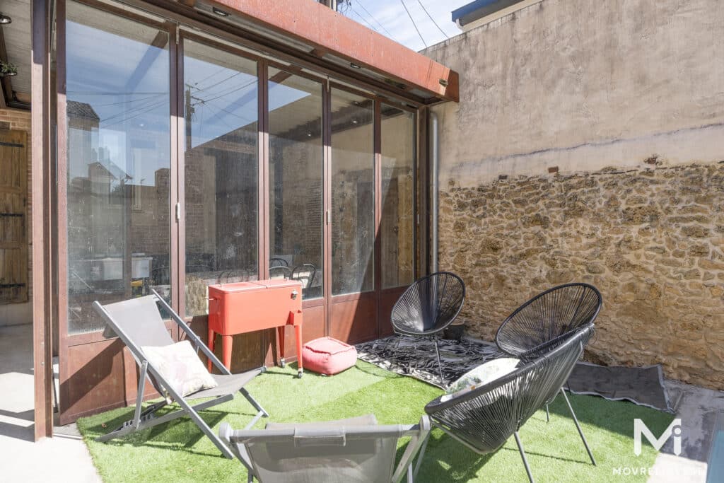 Terrasse en verre avec mobilier moderne et murs en pierre