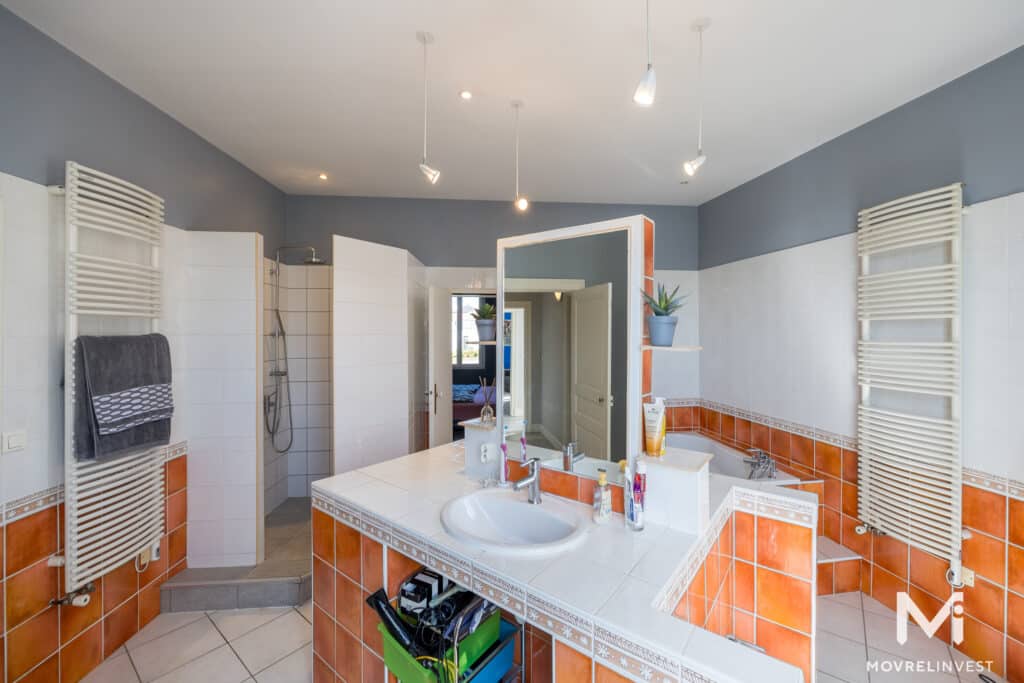 Salle de bain spacieuse avec carrelage orange et blanc