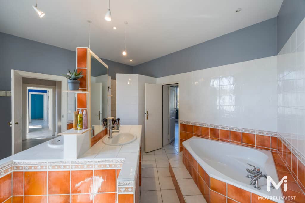 Salle de bain spacieuse avec baignoire et carrelage orange