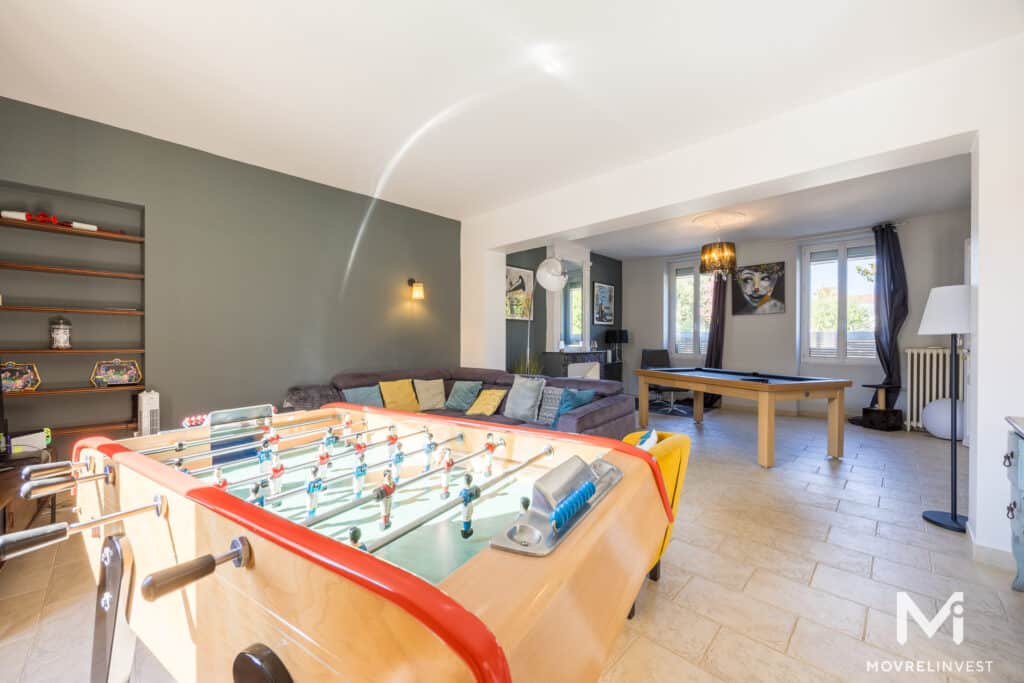 Salle de jeux lumineuse avec baby-foot et billard