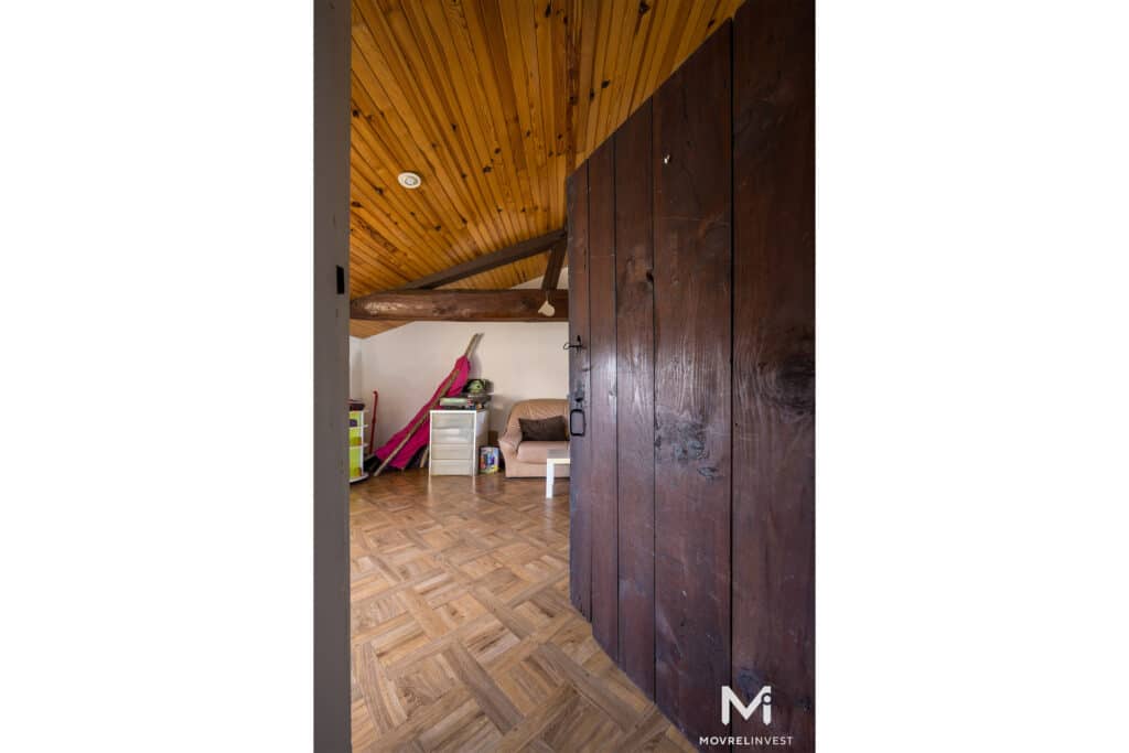 Intérieur mansardé avec boiseries et porte en bois foncé