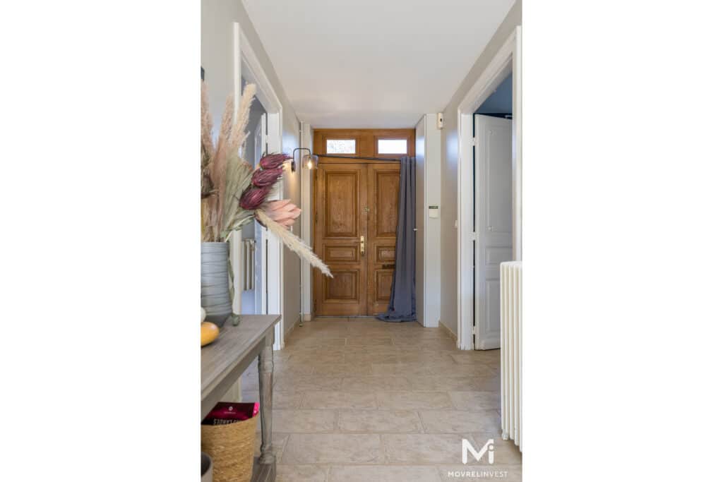 Couloir lumineux avec porte en bois et décorations