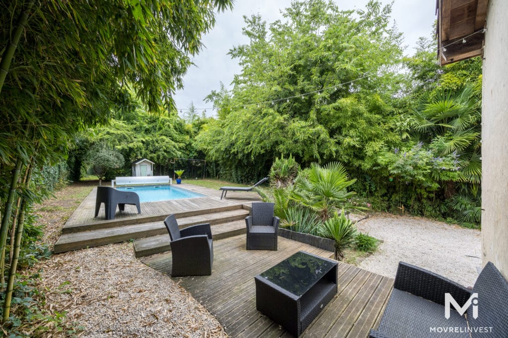 Jardin verdoyant avec piscine et mobilier extérieur moderne