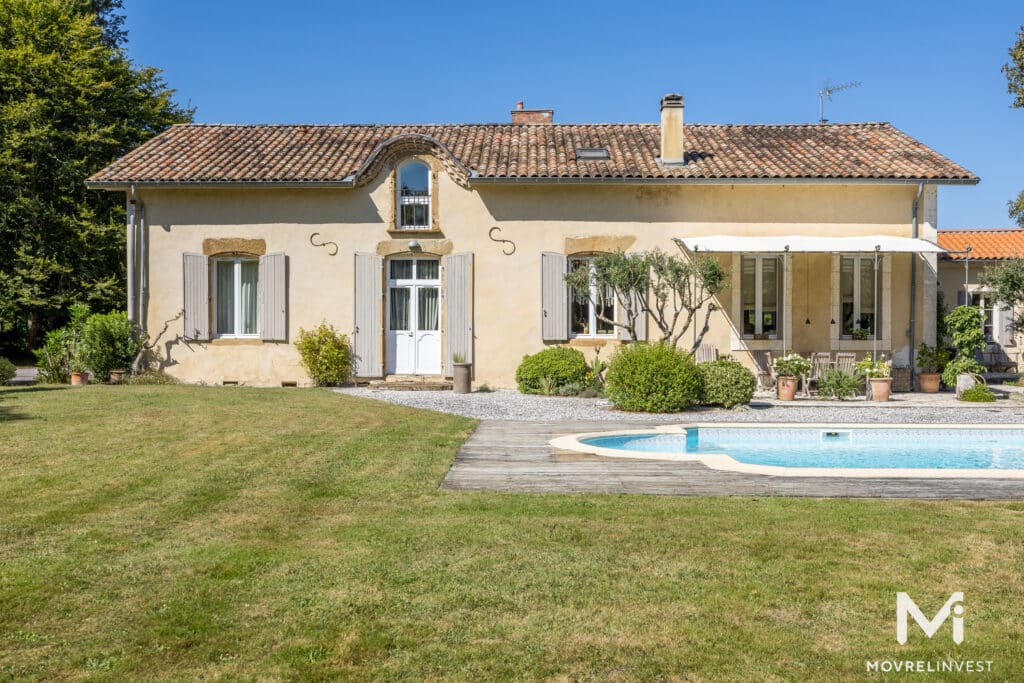 Maison champêtre avec piscine sous ciel bleu