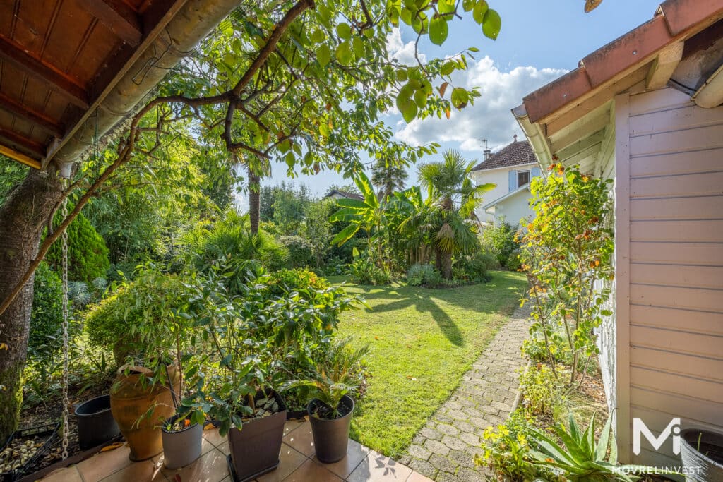 Jardin luxuriant avec maison en arrière-plan