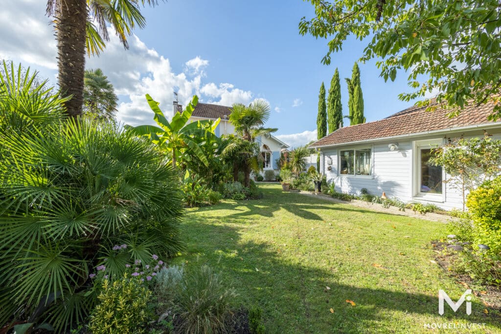 Maison blanche moderne entourée de jardins verdoyants