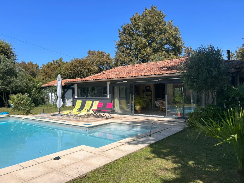 Maison moderne avec piscine et chaises longues colorées