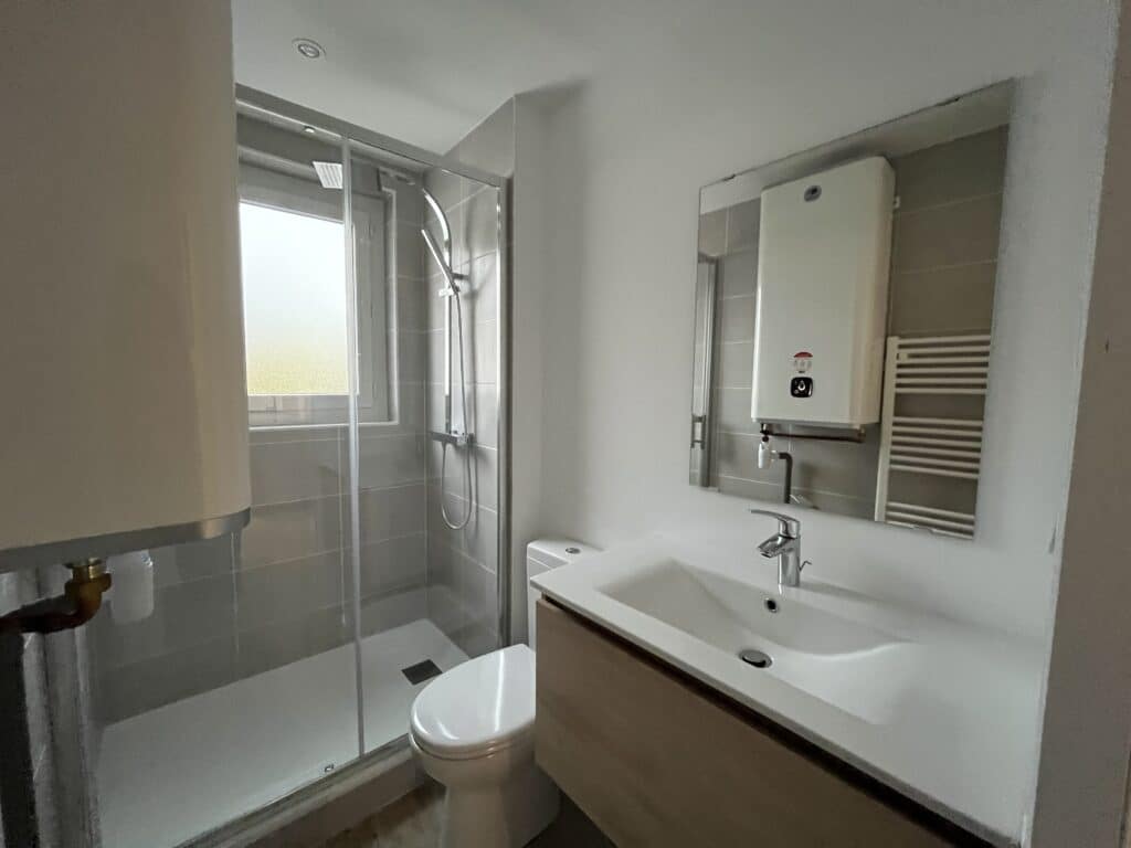 Salle de bain moderne avec douche et lavabo blancs