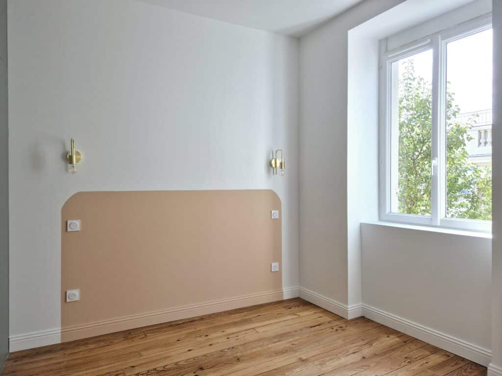 Chambre vide avec mur accent beige et fenêtre lumineuse