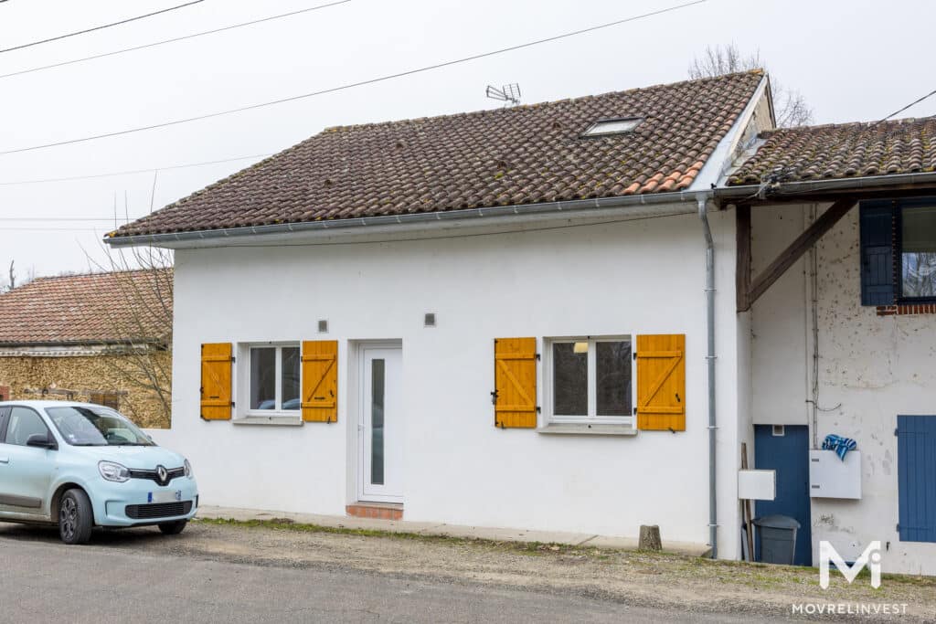 Maison blanche volets jaunes en France, voiture bleue