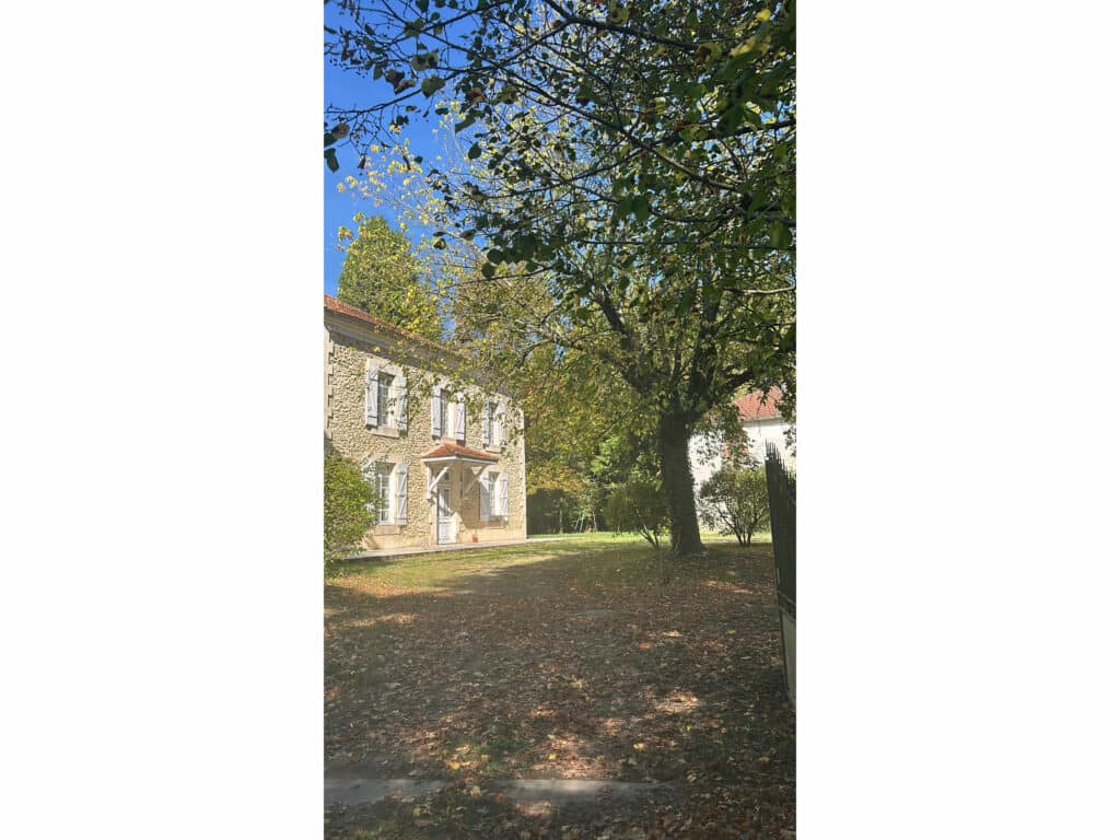 Maison historique avec arbres en automne, ciel clair