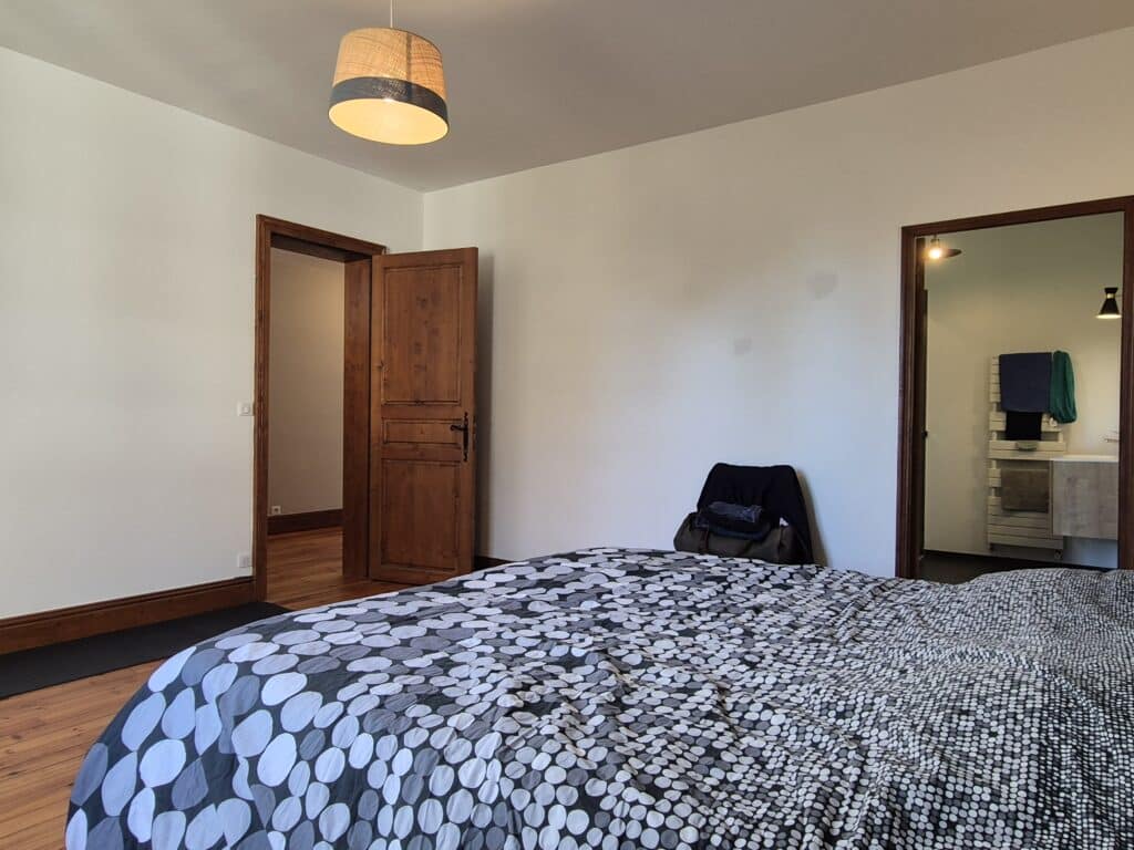 Chambre spacieuse avec lit double et portes en bois