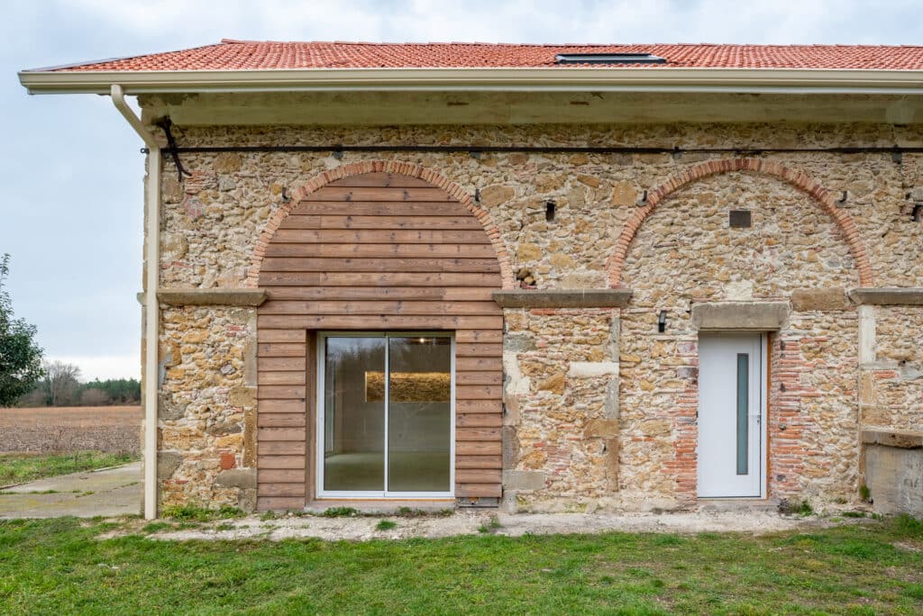 Maison en pierres avec détails en bois et toit rouge