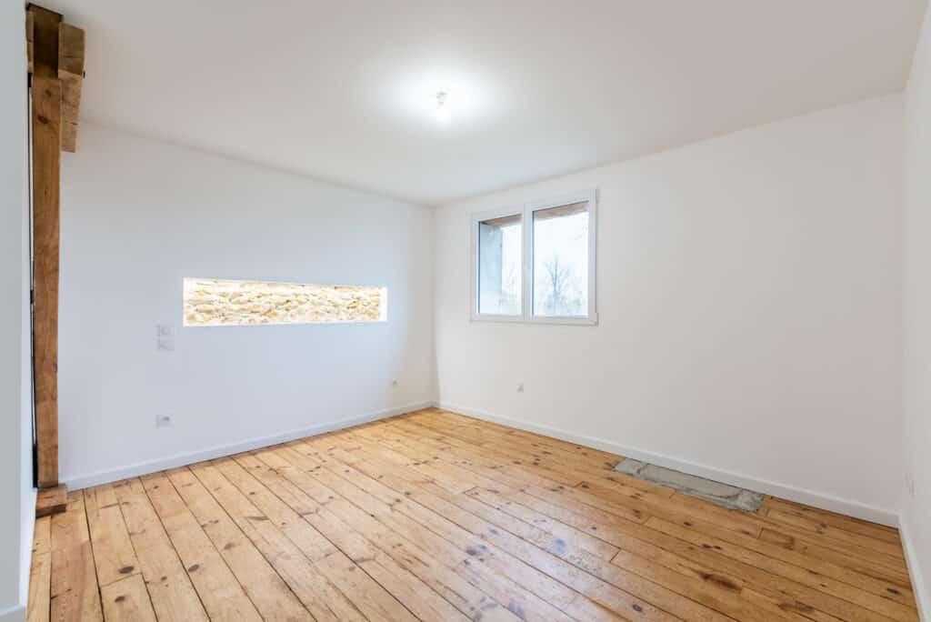 Pièce vide avec parquet et fenêtre lumineuse