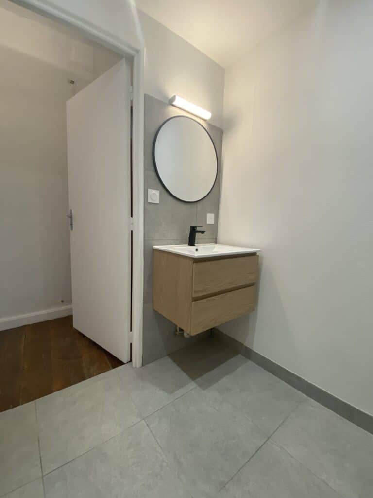 Salle de bain moderne avec miroir rond et éclairage LED