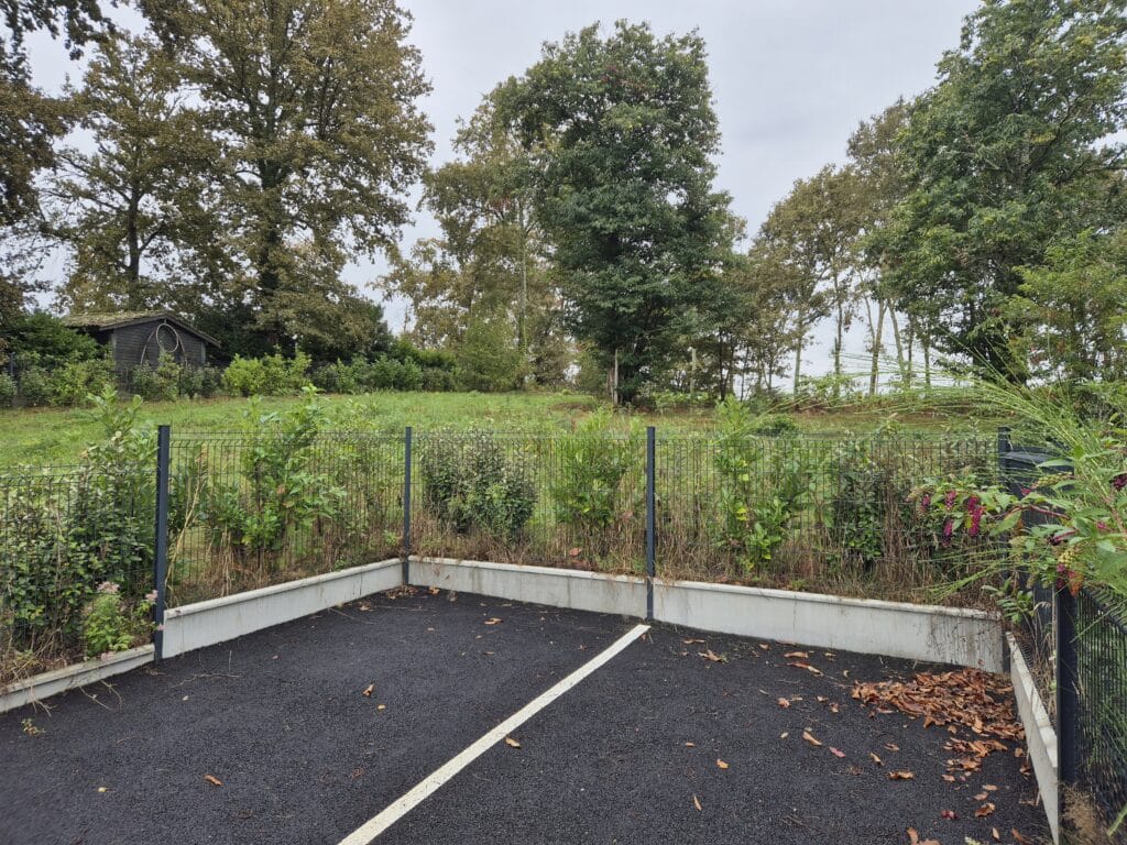 Parking vide avec clôture et cabane en forêt