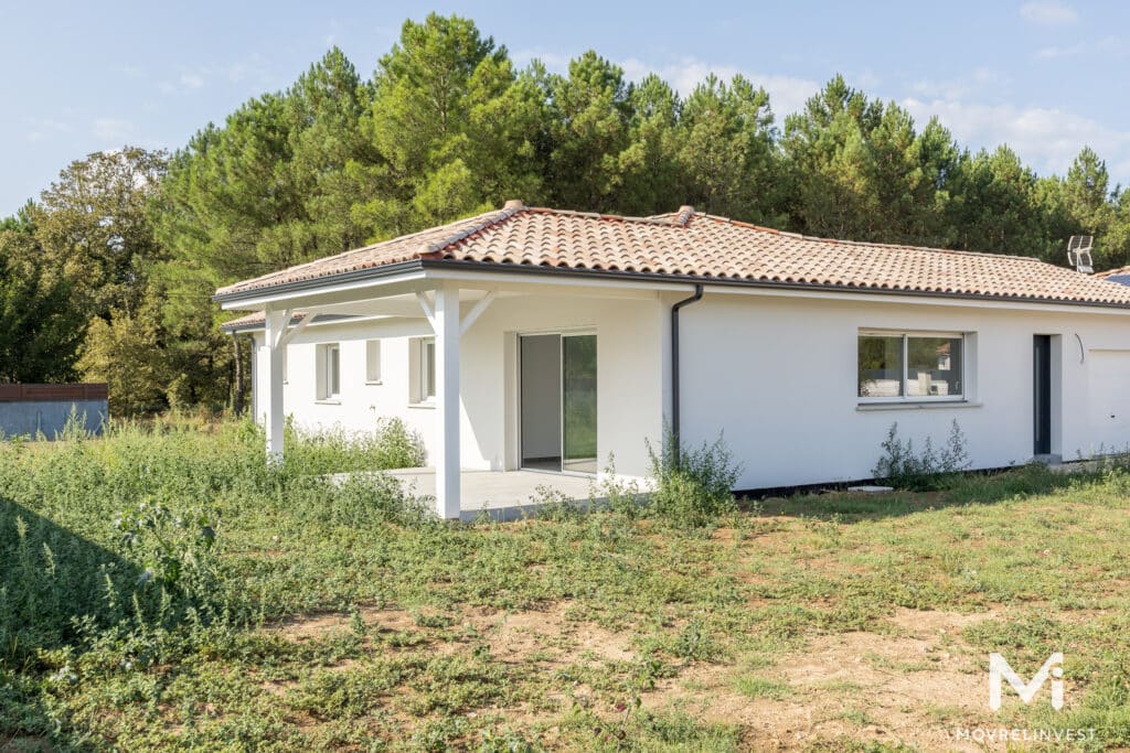 Maison moderne avec toit en tuiles, entourée d'arbres