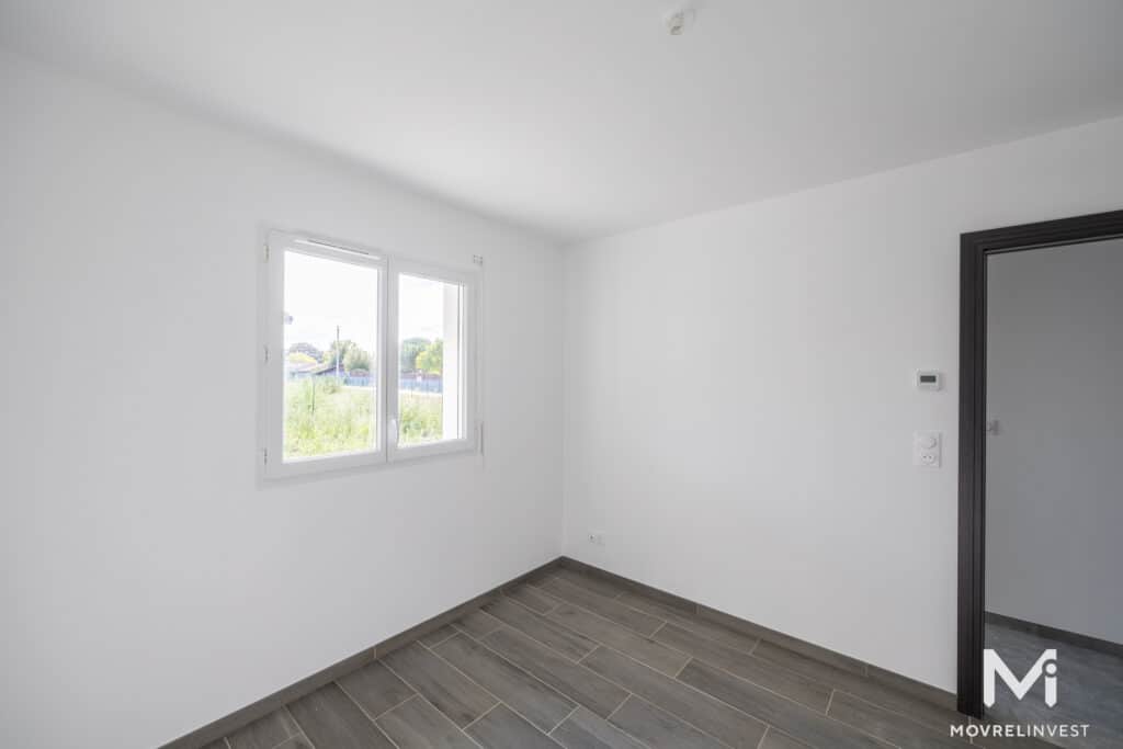 Chambre vide moderne avec fenêtre et parquet gris