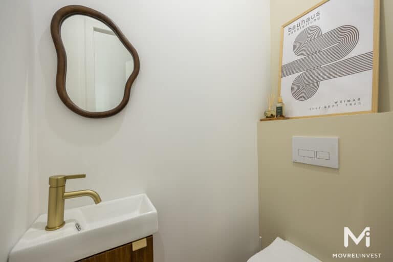 Salle de bain moderne avec miroir ovale et affiche