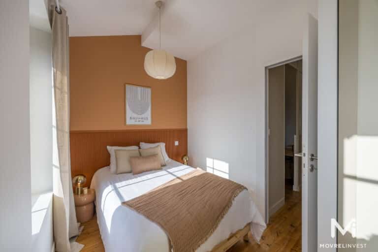 Chambre élégante avec mur orange et décor Bauhaus