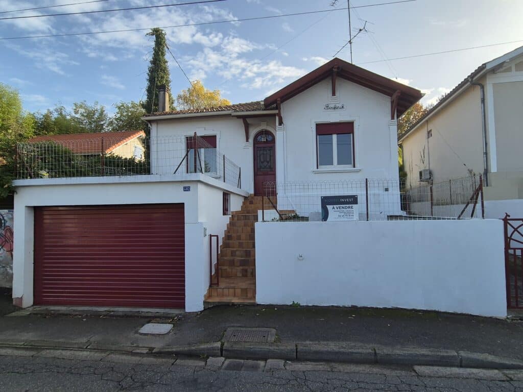 Maison blanche à vendre avec garage rouge