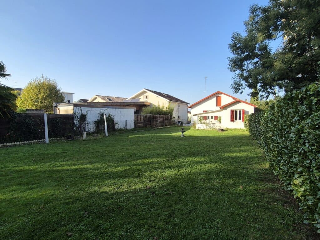 Maison moderne avec jardin verdoyant ensoleillé