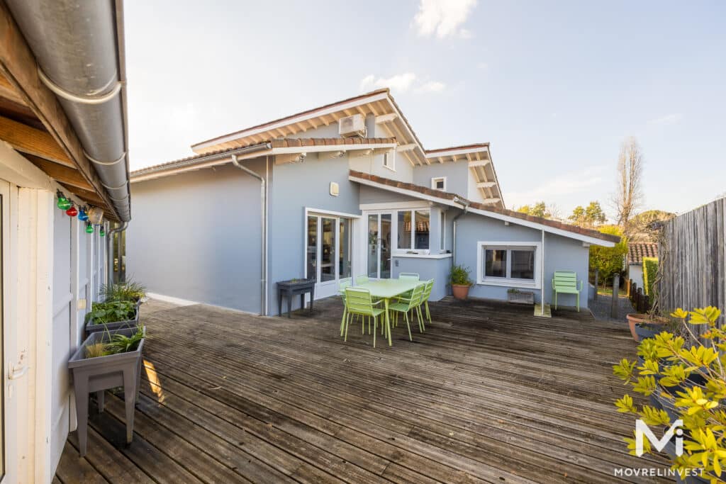 Maison moderne avec terrasse et mobilier vert