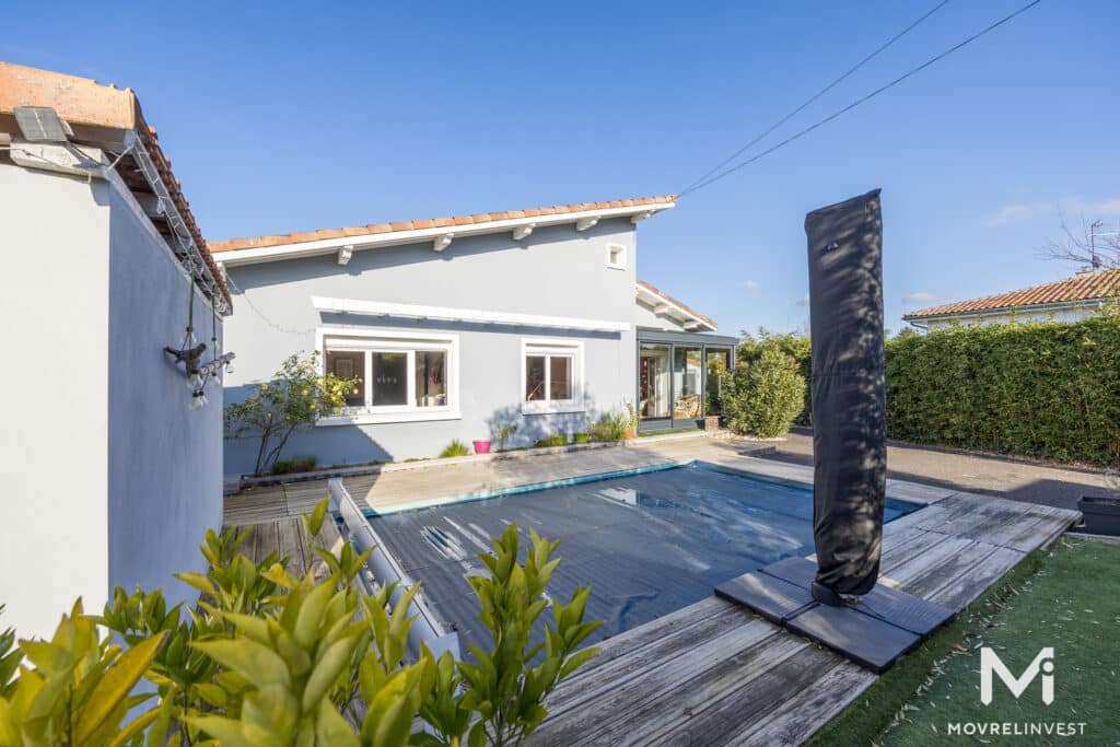 Maison moderne avec piscine sous ciel bleu