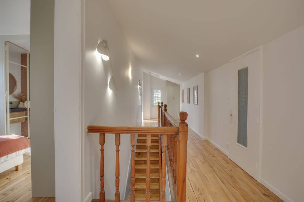 Couloir lumineux avec plancher en bois et balustrade