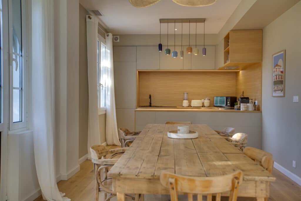 Cuisine moderne avec table en bois et luminaires colorés