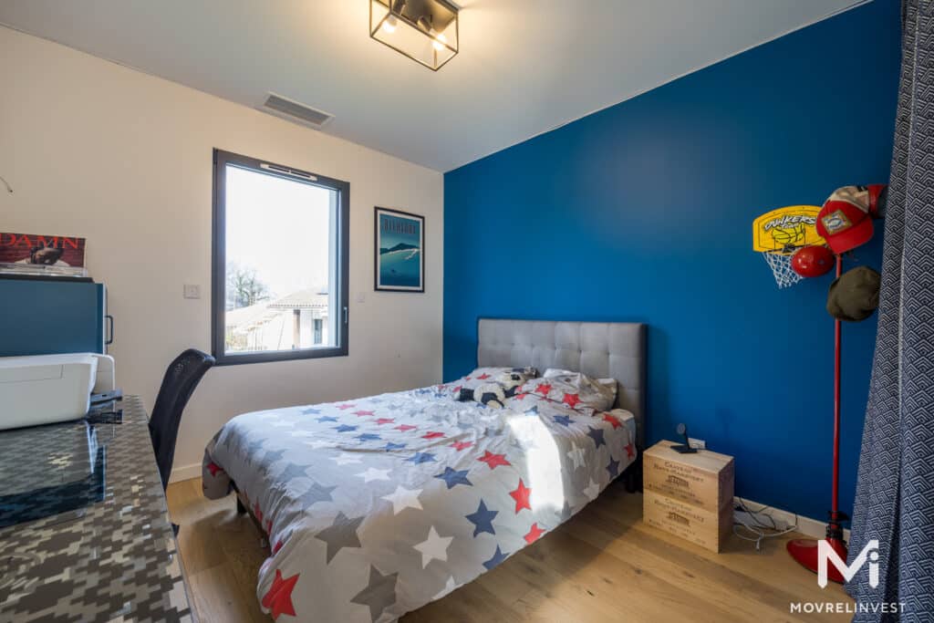 Chambre moderne avec mur bleu et lit étoilé